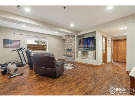 Fireplace, Fitness Equipment, Interior, Living room, Recessed Lighting, Stone Walls, Wood Texture Flooring