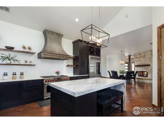 Chandelier, Dining room, Fireplace, Interior, Kitchen, Pendant Lights, Recessed Lighting, Stainless Steel Appliances, Stone Walls, Wood Texture Flooring