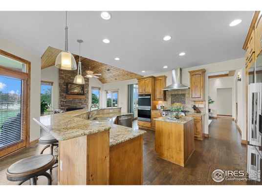 Fireplace, Interior, Kitchen, Pendant Lights, Recessed Lighting, Stainless Steel Appliances, Stone Walls, Wood Texture Flooring