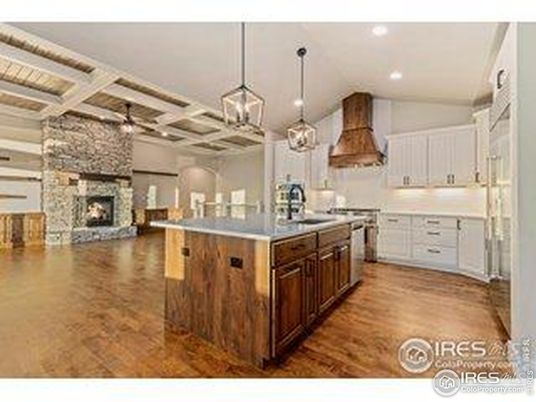 Fireplace, Interior, Kitchen, Pendant Lights, Recessed Lighting, Stainless Steel Appliances, Stone Walls, Wood Texture Flooring