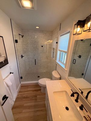 Bathroom, Dual Sink Vanities, Glass Shower, Interior, Marble Walls, Recessed Lighting, Wood Texture Flooring