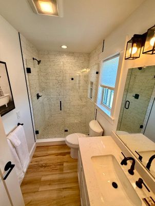 Bathroom, Dual Sink Vanities, Glass Shower, Interior, Marble Walls, Recessed Lighting, Wood Texture Flooring