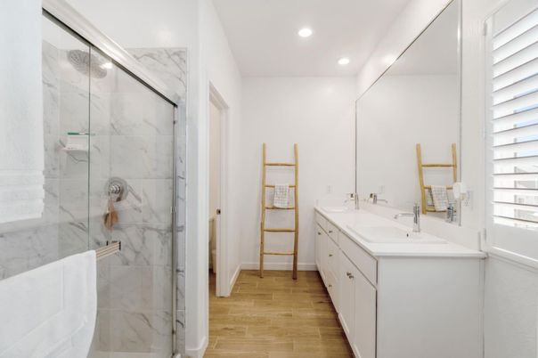 Bathroom, Dual Sink Vanities, Glass Shower, Interior, Marble Walls, Recessed Lighting, Wood Texture Flooring