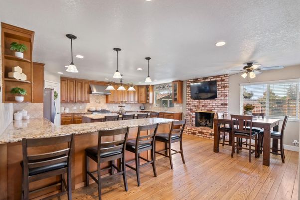 Dining room, Fireplace, Interior, Kitchen, Pendant Lights, Recessed Lighting, Stainless Steel Appliances, Stone Walls, Wood Texture Flooring