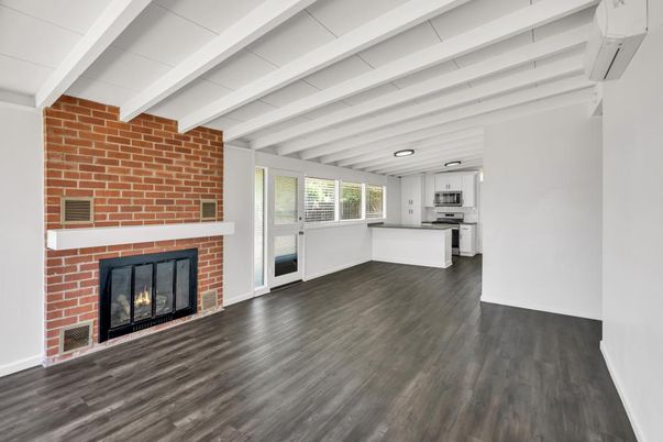 Empty room, Fireplace, Interior, Kitchen, Recessed Lighting, Stainless Steel Appliances, Stone Walls, Wood Texture Flooring