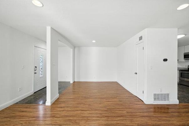 Empty room, Interior, Kitchen, Recessed Lighting, Stainless Steel Appliances, Wood Texture Flooring
