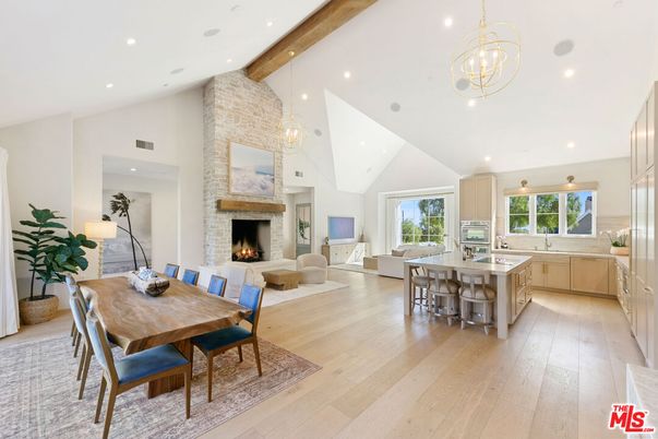 Chandelier, Dining room, Fireplace, Interior, Kitchen, Living room, Pendant Lights, Recessed Lighting, Stainless Steel Appliances, Stone Walls, Wooden Beams, Wood Texture Flooring