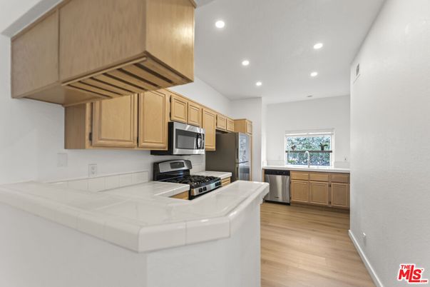 Interior, Kitchen, Recessed Lighting, Stainless Steel Appliances, Tile Countertops, Wood Texture Flooring