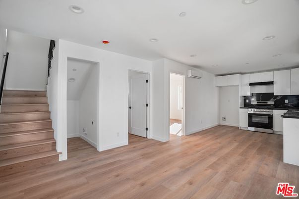 Empty room, Interior, Kitchen, Recessed Lighting, Stainless Steel Appliances, Wood Texture Flooring