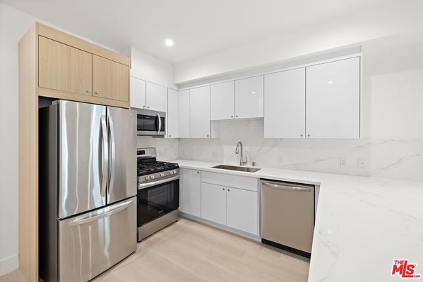 Interior, Kitchen, Marble Walls, Recessed Lighting, Stainless Steel Appliances, Wood Texture Flooring