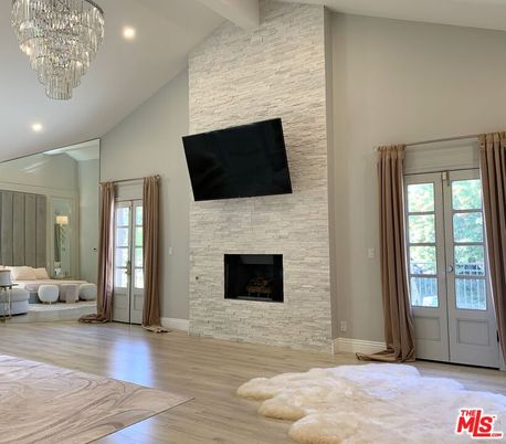 Chandelier, Fireplace, Interior, Recessed Lighting, Stone Walls, Wood Texture Flooring