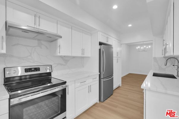 Interior, Kitchen, Marble Walls, Recessed Lighting, Stainless Steel Appliances, Wood Texture Flooring