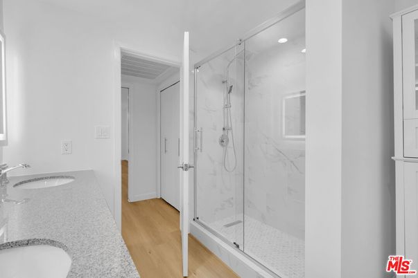Bathroom, Dual Sink Vanities, Glass Shower, Interior, Marble Walls, Recessed Lighting, Wood Texture Flooring