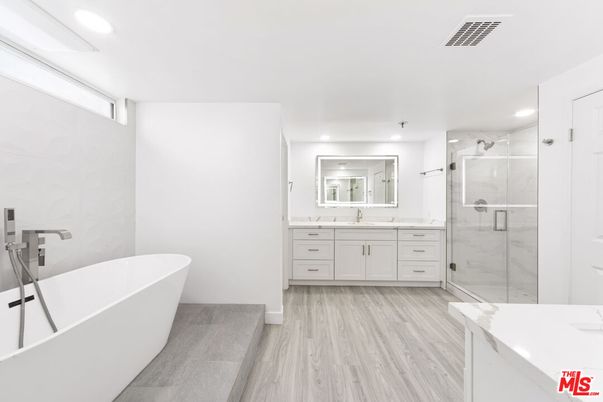 Bathroom, Dual Sink Vanities, Free Standing Baths, Glass Shower, Interior, Marble Walls, Recessed Lighting, Wood Texture Flooring