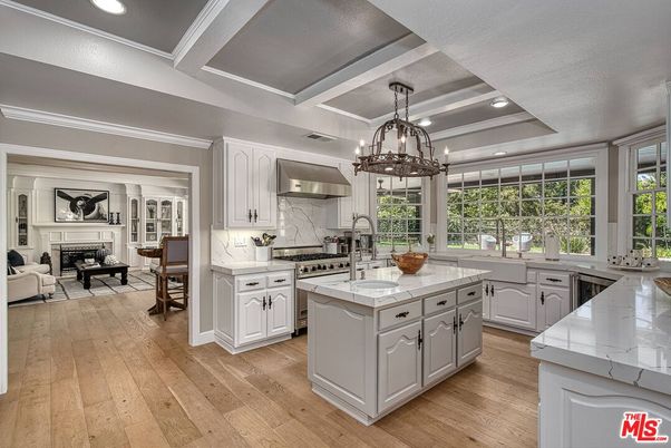 Chandelier, Fireplace, Interior, Kitchen, Living room, Pendant Lights, Recessed Lighting, Stainless Steel Appliances, Wood Texture Flooring