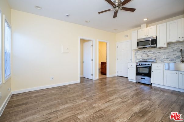 Empty room, Interior, Kitchen, Recessed Lighting, Stainless Steel Appliances, Wood Texture Flooring