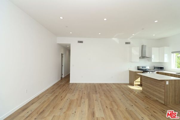 Empty room, Interior, Kitchen, Recessed Lighting, Stainless Steel Appliances, Wood Texture Flooring