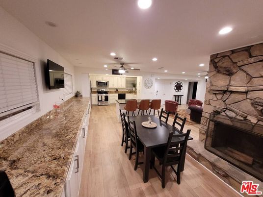 Dining room, Fireplace, Interior, Kitchen, Recessed Lighting, Stainless Steel Appliances, Stone Walls, Wood Texture Flooring