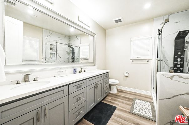 Bathroom, Dual Sink Vanities, Interior, Marble Walls, Recessed Lighting, Wood Texture Flooring