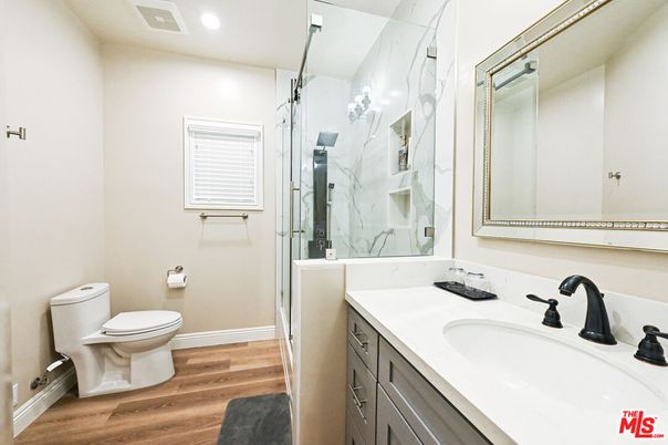 Bathroom, Dual Sink Vanities, Glass Shower, Interior, Marble Walls, Recessed Lighting, Wood Texture Flooring