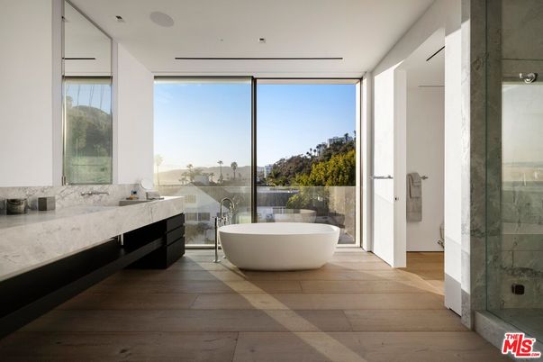Bathroom, Dual Sink Vanities, Free Standing Baths, Glass Shower, Interior, Marble Walls, Recessed Lighting, Wood Texture Flooring