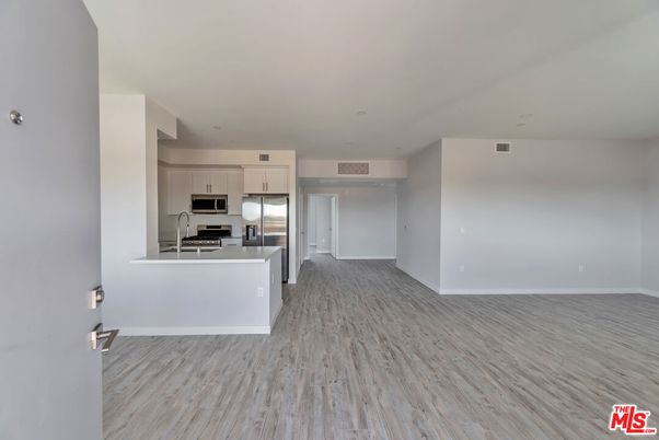 Empty room, Interior, Kitchen, Recessed Lighting, Stainless Steel Appliances, Wood Texture Flooring