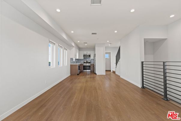 Empty room, Interior, Kitchen, Recessed Lighting, Stainless Steel Appliances, Wood Texture Flooring