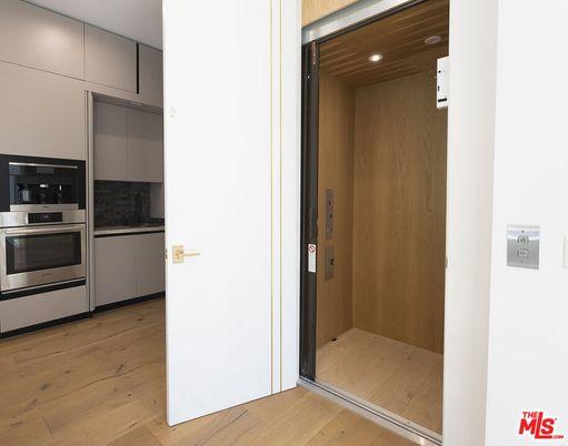 Elevator, Interior, Kitchen, Recessed Lighting, Stainless Steel Appliances, Wood Texture Flooring, Wooden Walls