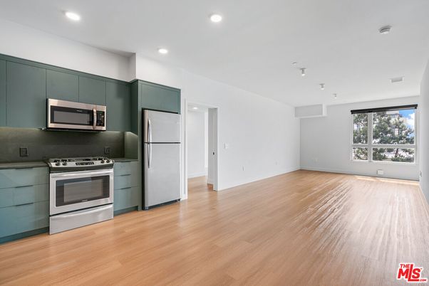 Empty room, Interior, Kitchen, Recessed Lighting, Stainless Steel Appliances, Wood Texture Flooring