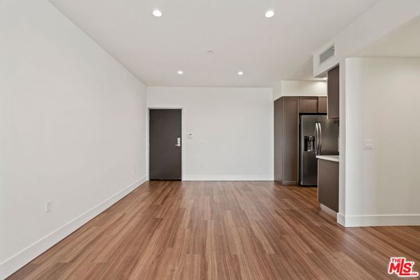 Empty room, Interior, Kitchen, Recessed Lighting, Stainless Steel Appliances, Wood Texture Flooring