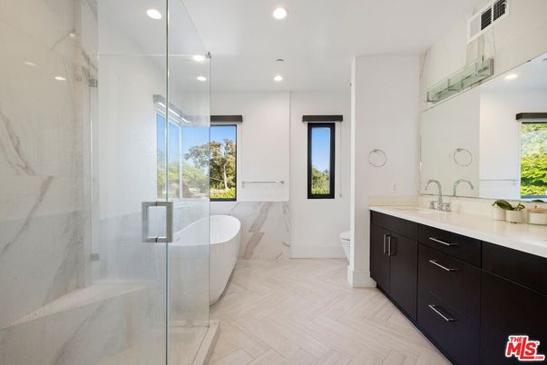 Bathroom, Dual Sink Vanities, Free Standing Baths, Glass Shower, Interior, Marble Walls, Recessed Lighting, Wood Texture Flooring