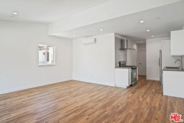 Empty room, Interior, Kitchen, Recessed Lighting, Stainless Steel Appliances, Wood Texture Flooring