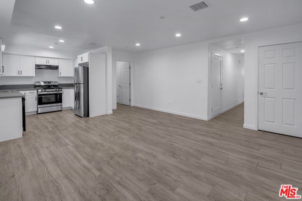 Empty room, Interior, Kitchen, Recessed Lighting, Stainless Steel Appliances, Wood Texture Flooring