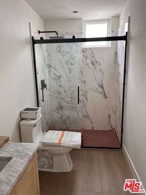 Bathroom, Glass Shower, Interior, Marble Walls, Recessed Lighting, Wood Texture Flooring