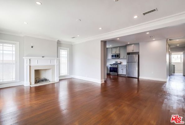 Empty room, Fireplace, Interior, Kitchen, Recessed Lighting, Stainless Steel Appliances, Wood Texture Flooring