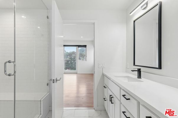 Bathroom, Dual Sink Vanities, Glass Shower, Interior, Marble, Recessed Lighting, Wood Texture Flooring