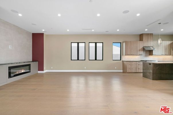 Empty room, Fireplace, Interior, Kitchen, Pendant Lights, Recessed Lighting, Stainless Steel Appliances, Wood Texture Flooring