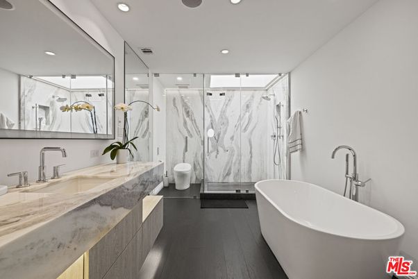 Bathroom, Dual Sink Vanities, Free Standing Baths, Glass Shower, Interior, Marble Walls, Recessed Lighting, Wood Texture Flooring