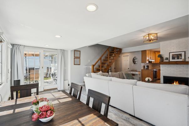Dining room, Fireplace, Interior, Living room, Recessed Lighting, Stone Walls, Wood Texture Flooring