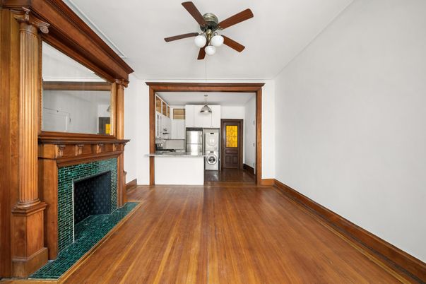Empty room, Fireplace, Interior, Kitchen, Pendant Lights, Stainless Steel Appliances, Wood Texture Flooring