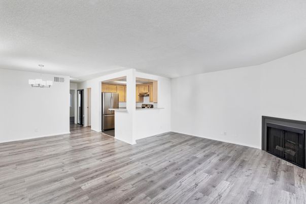Chandelier, Empty room, Fireplace, Interior, Kitchen, Pendant Lights, Stainless Steel Appliances, Wood Texture Flooring