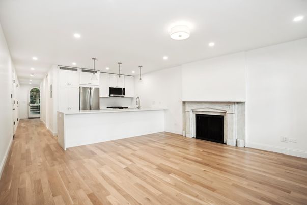 Empty room, Fireplace, Interior, Kitchen, Pendant Lights, Recessed Lighting, Stainless Steel Appliances, Wood Texture Flooring