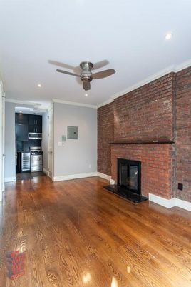 Empty room, Fireplace, Interior, Kitchen, Recessed Lighting, Stainless Steel Appliances, Stone Walls, Wood Texture Flooring