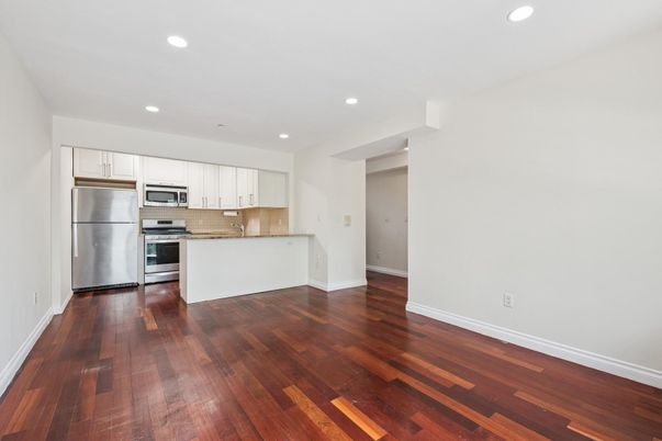 Empty room, Interior, Kitchen, Recessed Lighting, Stainless Steel Appliances, Wood Texture Flooring