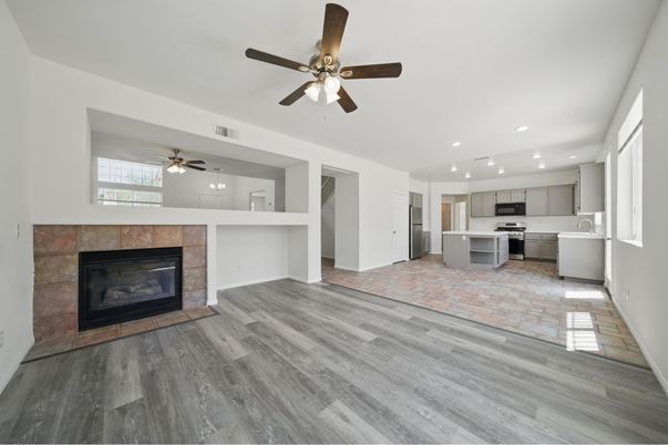 Empty room, Fireplace, Interior, Kitchen, Recessed Lighting, Stainless Steel Appliances, Wood Texture Flooring
