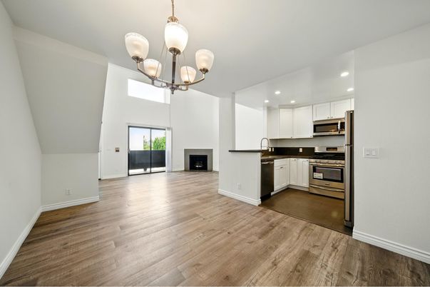 Chandelier, Empty room, Fireplace, Interior, Kitchen, Recessed Lighting, Stainless Steel Appliances, Wood Texture Flooring