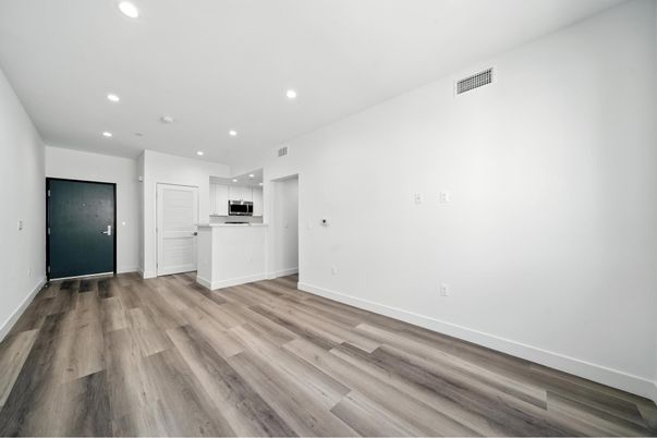 Empty room, Interior, Kitchen, Recessed Lighting, Stainless Steel Appliances, Wood Texture Flooring