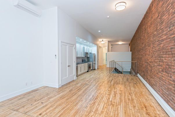Empty room, Interior, Kitchen, Recessed Lighting, Stainless Steel Appliances, Stone Walls, Wood Texture Flooring