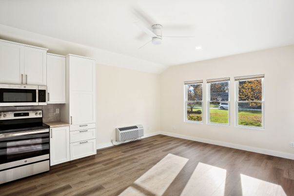 Empty room, Interior, Kitchen, Recessed Lighting, Stainless Steel Appliances, Wood Texture Flooring