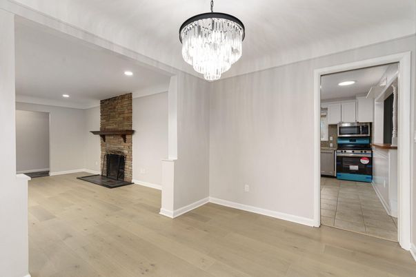 Chandelier, Fireplace, Interior, Kitchen, Recessed Lighting, Stainless Steel Appliances, Stone Walls, Wood Texture Flooring